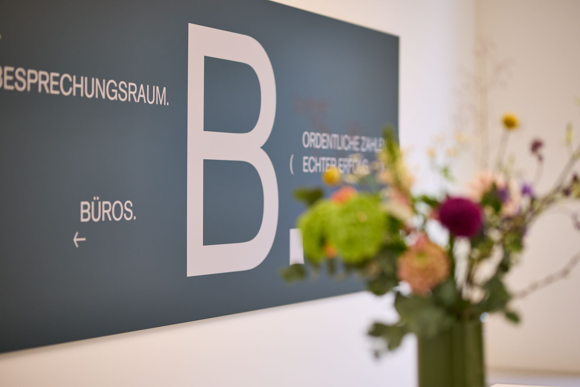 Ein Schild an der Wand mit einem großem B und eine art Orientierungshilfe