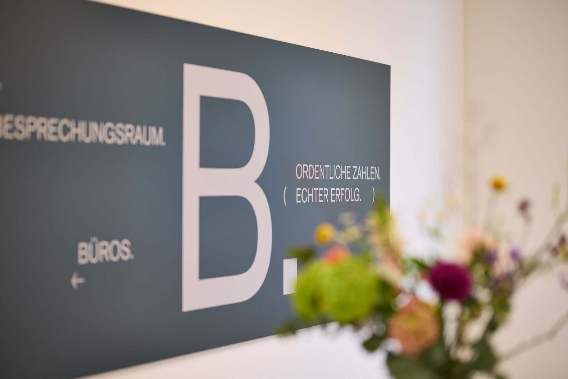 Ein Schild an der Wand mit einem großem B und eine art Orientierungshilfe