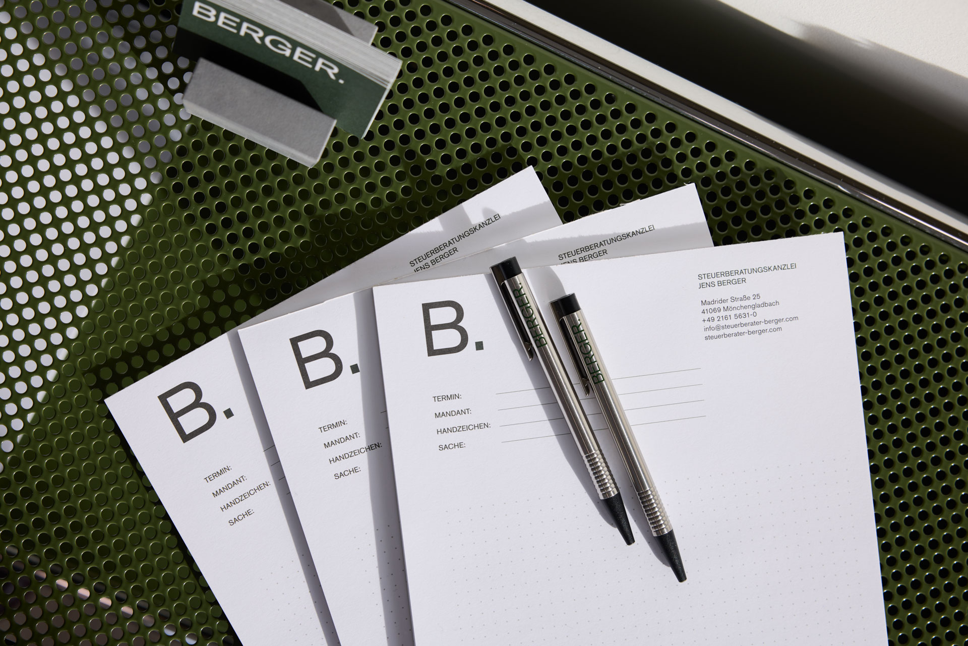 Blöcke mit Kugelschreiber und Visitenkarten im Regal