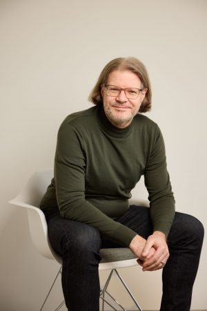 Ein Bild von Jens Berger sitzend auf ein Stühl